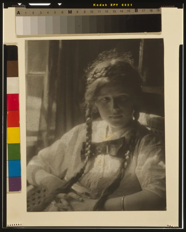 girl-braids-white-dress-bow-hands-folded-seated female