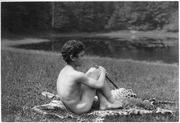 nude-youth-pipe-seated-leopard-skin-nature male