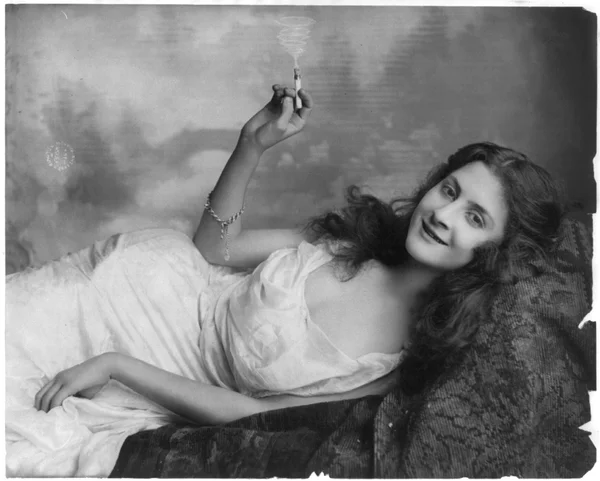 young-woman-lying-sofa-holding-burning-cigarette female